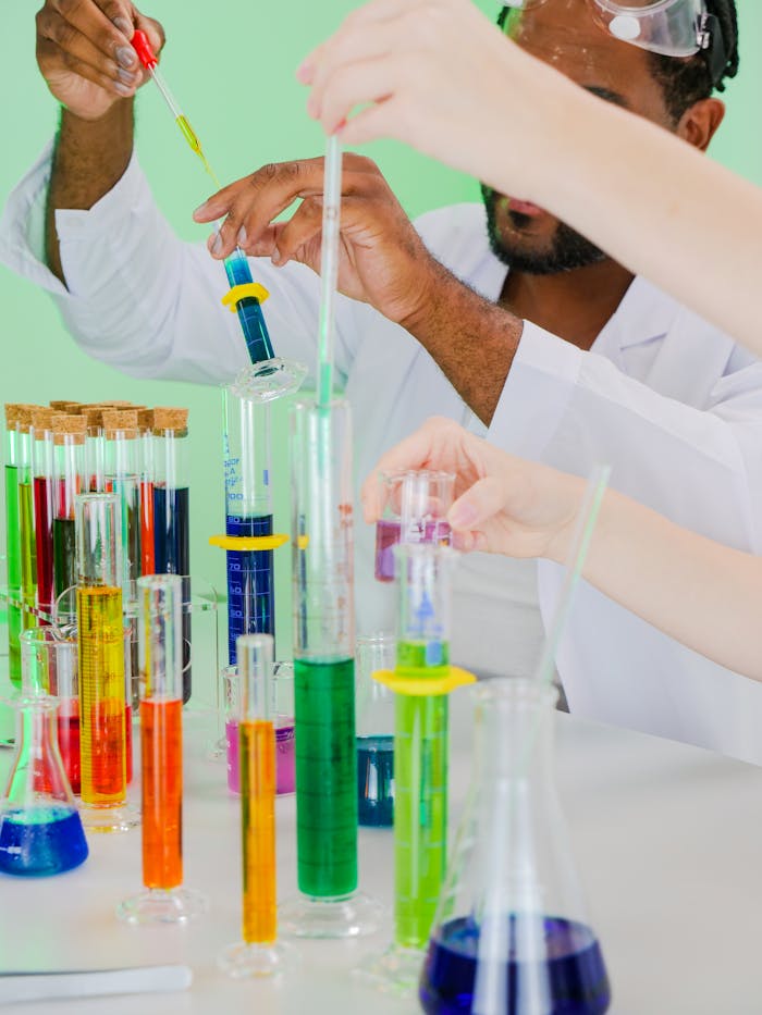 Researchers in lab coats conducting chemical experiments with colorful liquids.